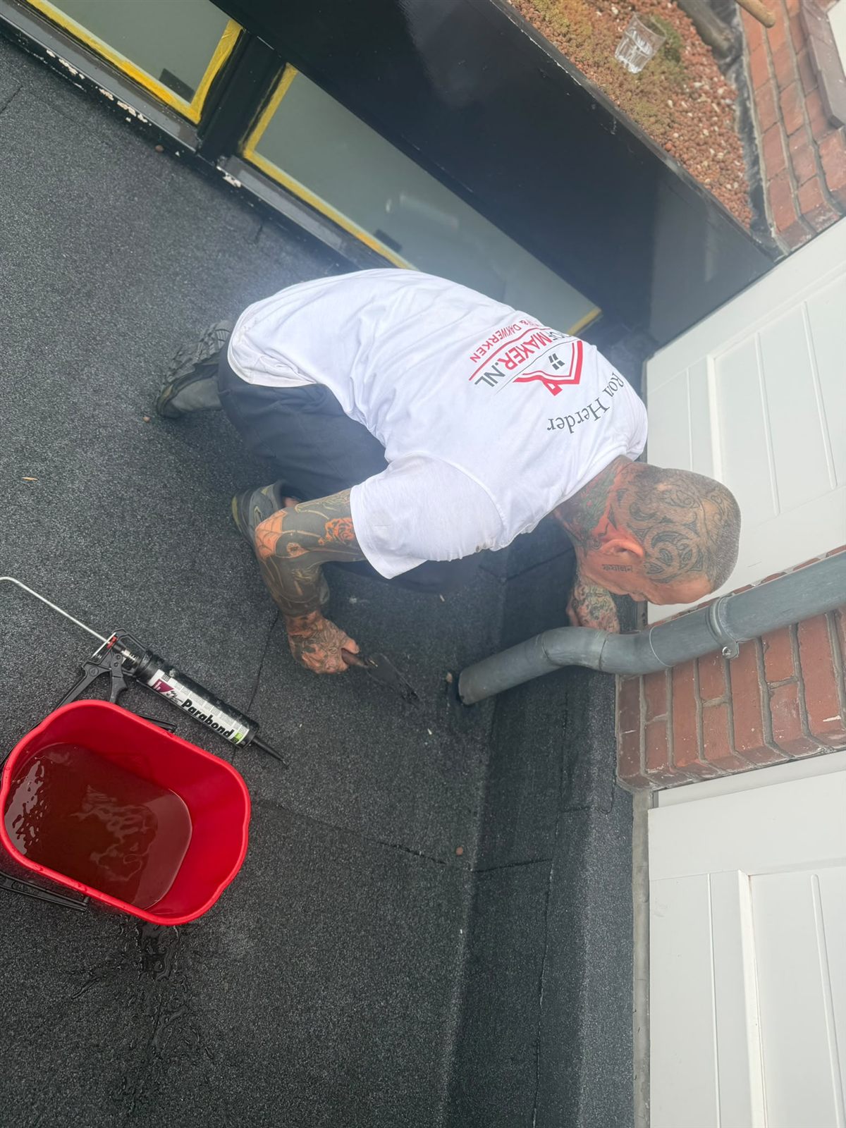 Roofmaker dakdekker werkt aan de aansluiting van een plat dak