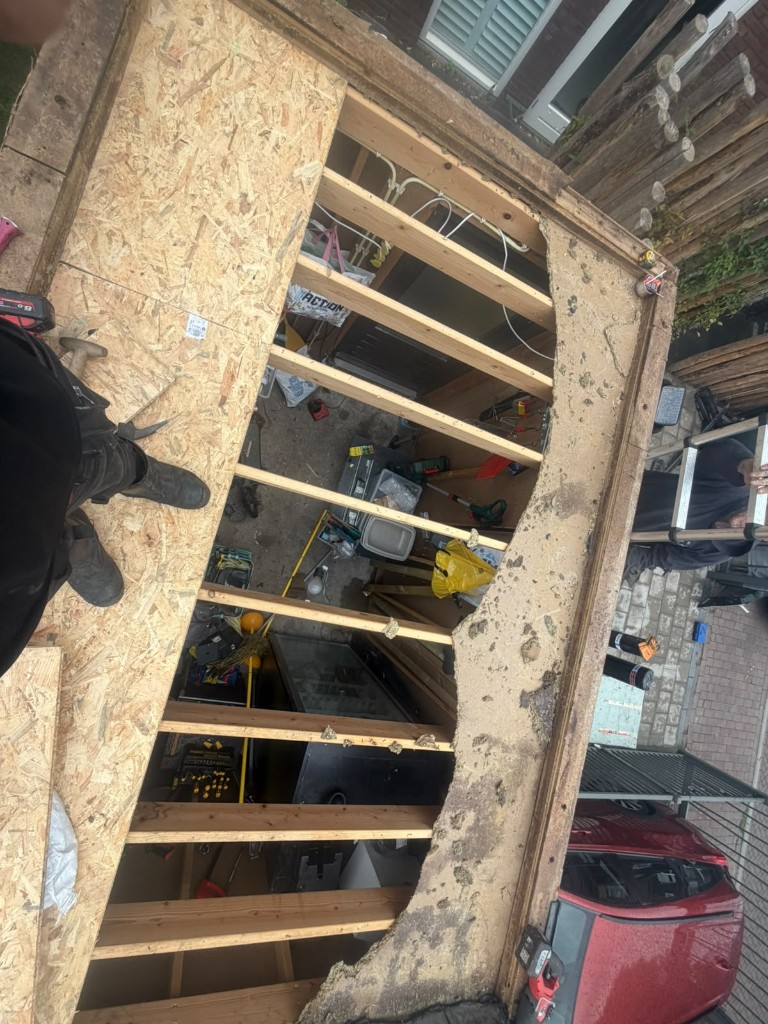 Geopende dakconstructie en balklaag tijdens de renovatie van een garage