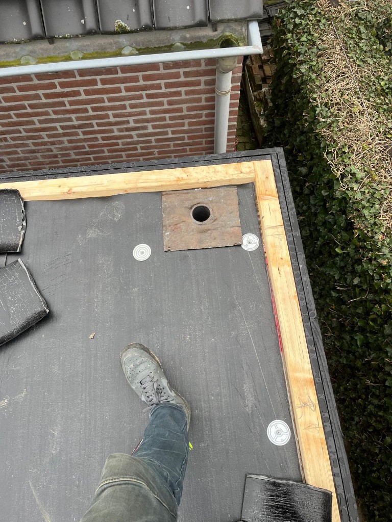 Detail van de voorbereide dakafvoer en houten dakrand van de berging