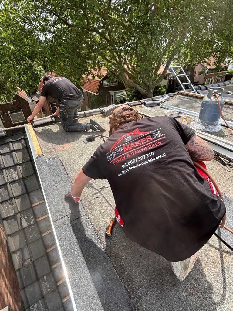 Twee dakspecialisten van Roofmaker aan het werk op plat dak